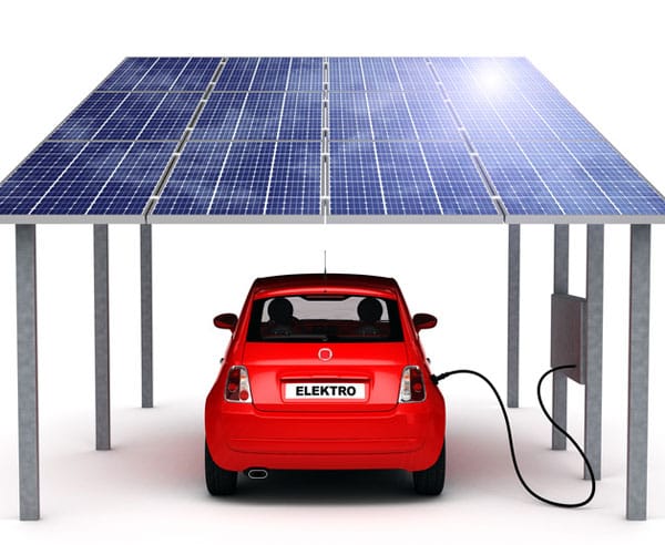Elektromobil nabíjaný pod fotovoltickým prístreškom pri rodinnom dome